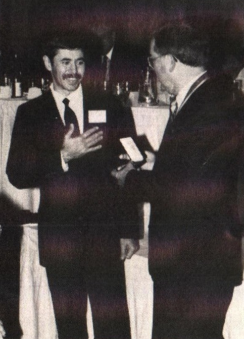 At the ANA's convention in Seattle, Alex Shagin (left) accepts the Numismatic Art Award for Excellence in Medaille Sculpture from ANA President Ken Hallenbeck.