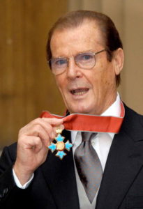 Sir Roger Moore receiving his Knighthood for charitable services at Buckingham Palace on October 8, 2003. (Photo by Anwar Hussein/WireImage)